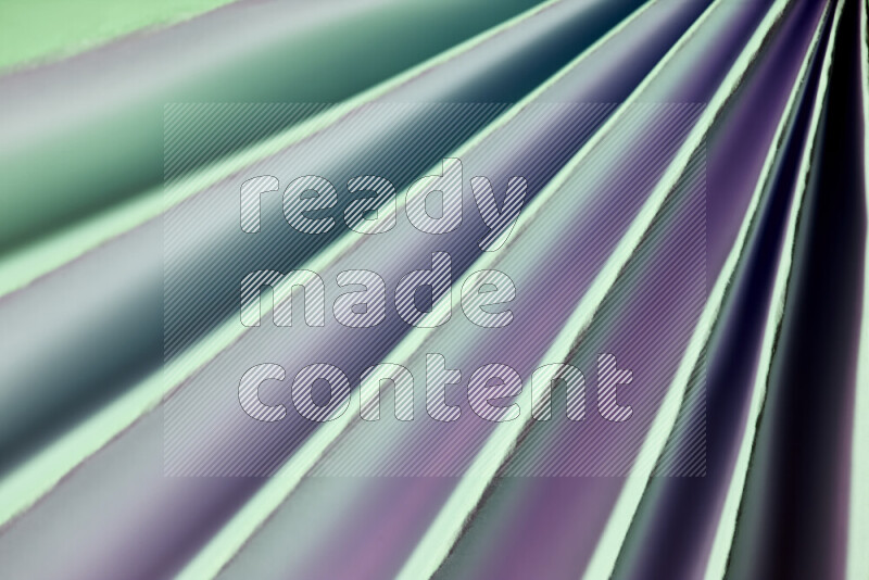 An image presenting an abstract paper pattern of lines in green and pink tones