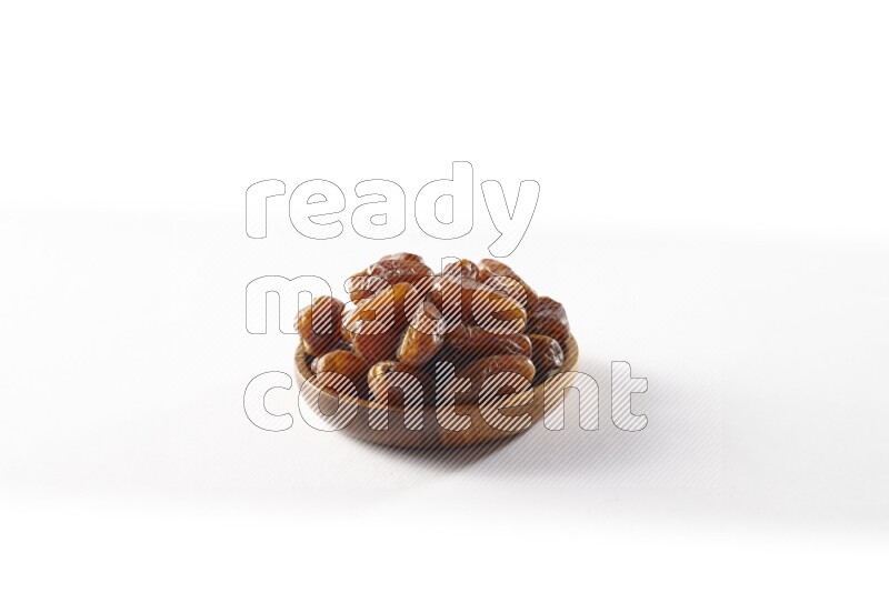 Dates in a wooden bowl on white background
