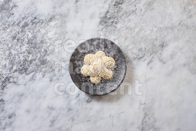 Kahk in black pottery plate on grey marble background