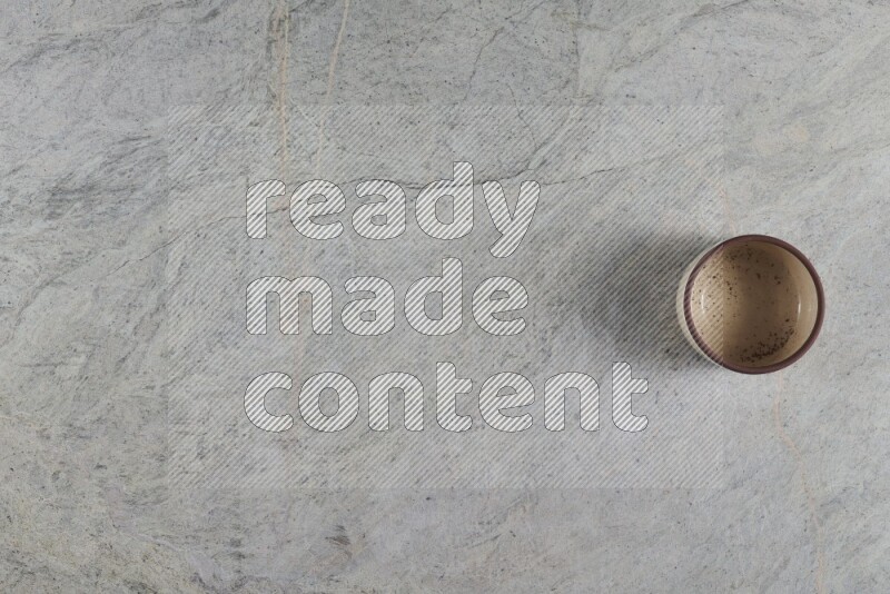 وعاء فخاري متعدد الألوان على خلفية من الرخام الرمادي