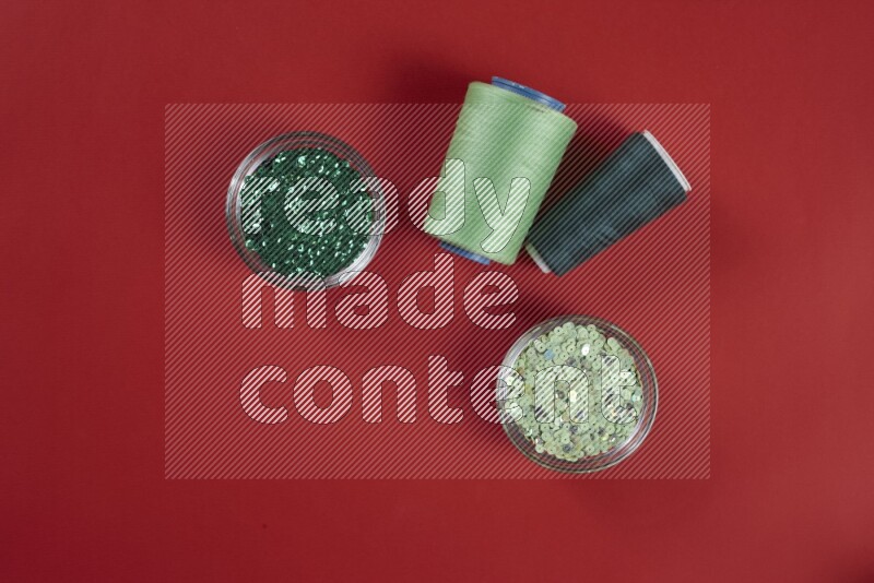 A green and red collection of sewing and tailoring tools arranged on a red background