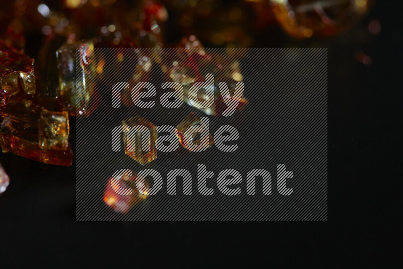 قطع زجاج برتقالية شفافة متناثرة على خلفية سوداء