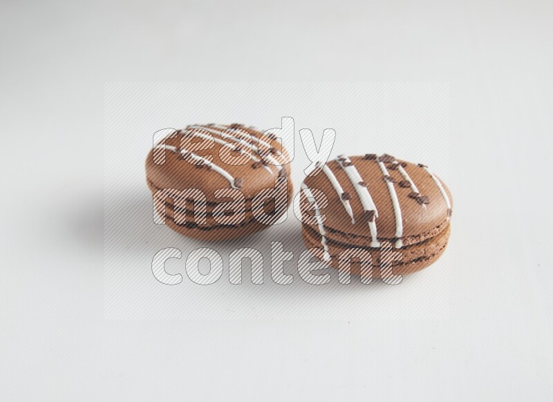 45º Shot of two Brown white Chocolate Caramel macarons on white background