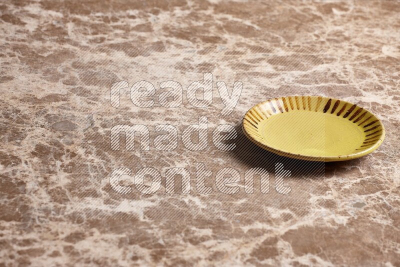 A multicolored pottery plate on beige marble background