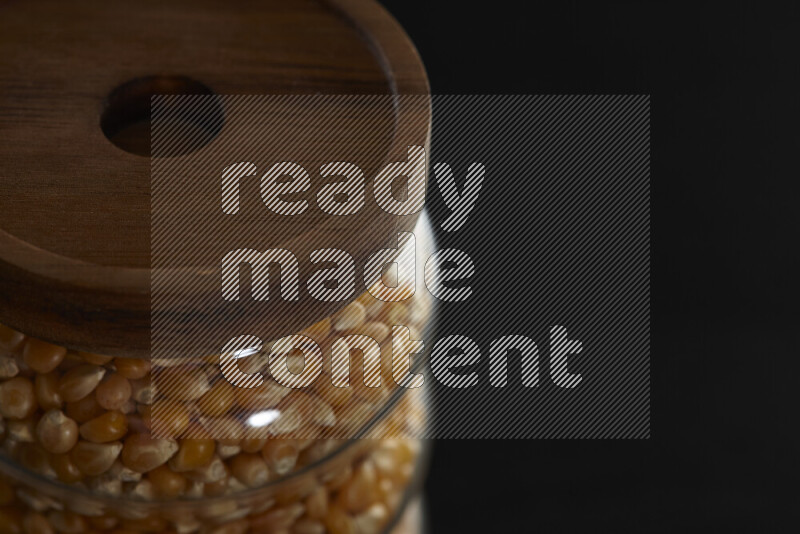 Pop corn in a glass jar on black background