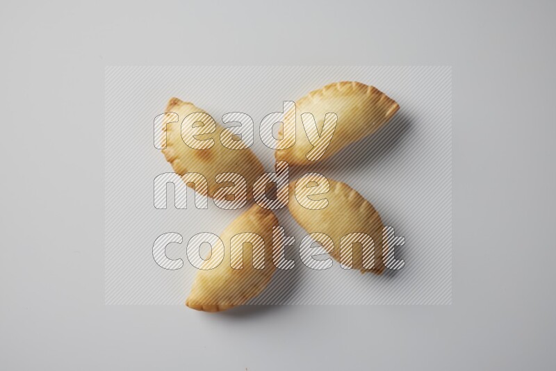 Four fried sambosa from a top angle on a white background