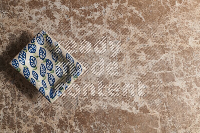 A decorative pottery plate on beige marble background
