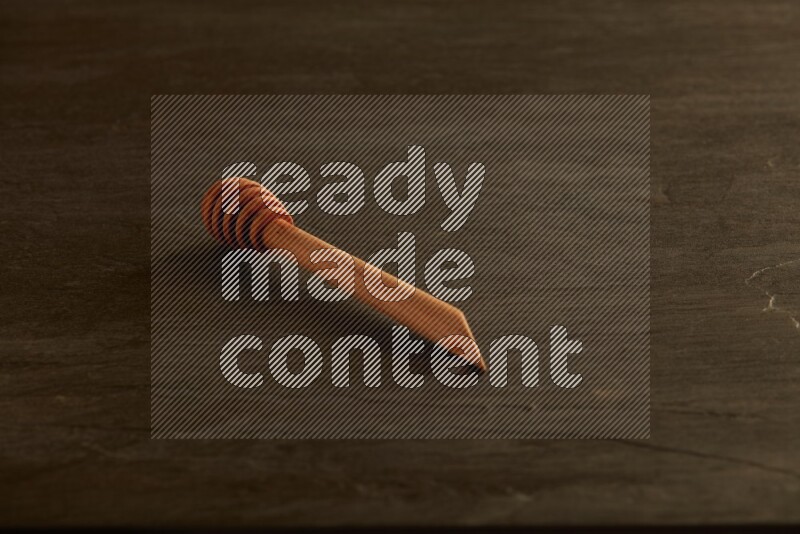 Wooden honey dipper on black slate background