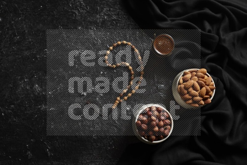 Nuts in pottery bowls with coffee in a dark setup