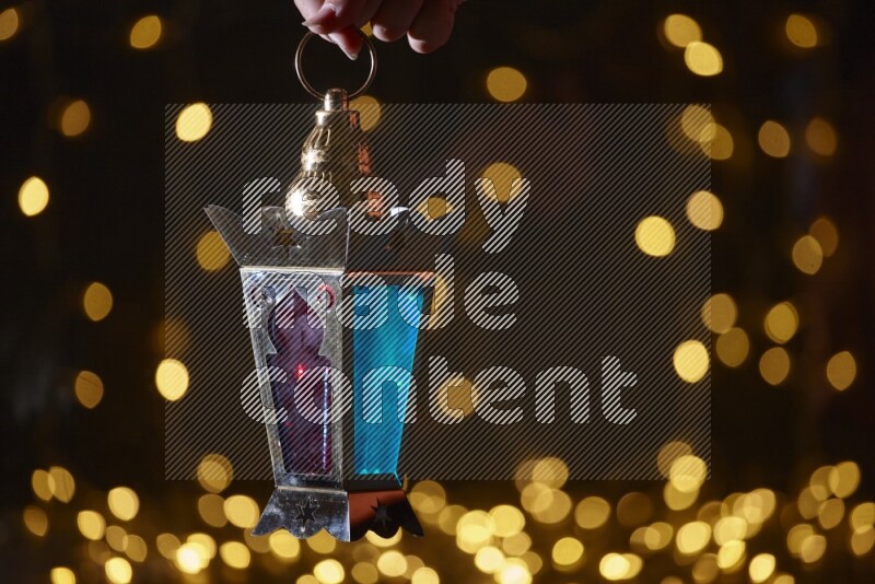 A traditional ramadan lantern surrounded by glowing fairy lights in a dark setup