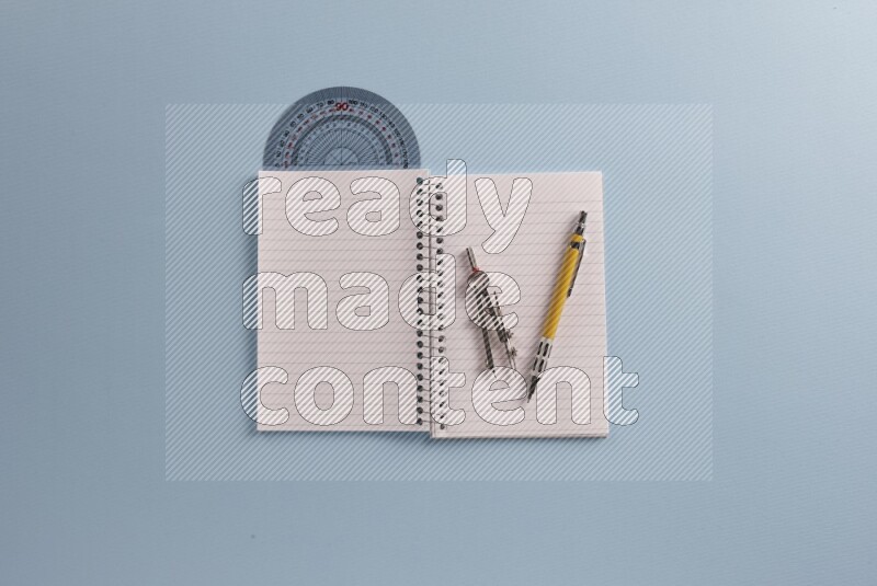 A blank open notebook with different school supplies on blue background