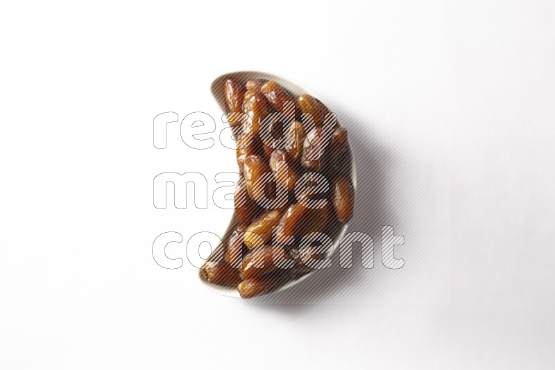 Dates in a crescent pottery plate on white background