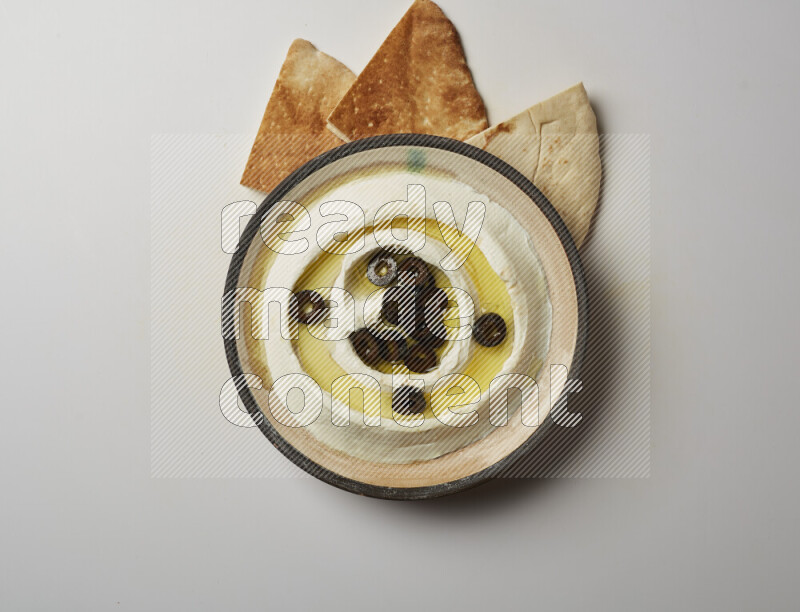 Lebnah garnished with sliced olives in a pottery plate on a white background
