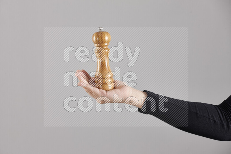 امرأة ترتدي عباءة سوداء تحمل أدوات خشبية مختلفة في أوضاع متعددة