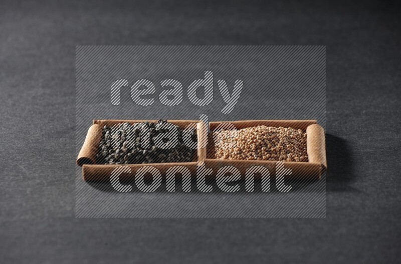 2 squares of cinnamon sticks full of mustard seeds and black peppers on black flooring