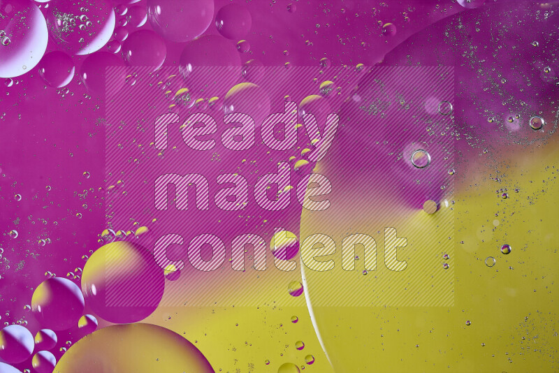 لقطات مقربة لفقاعات من الزيت على سطح الماء باللون الأصفر والوردي