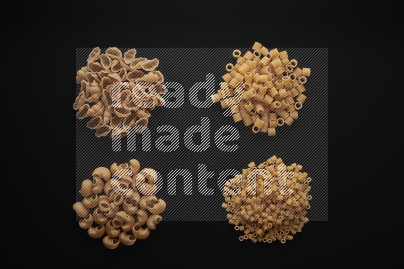 Different pasta types in bunches on black background