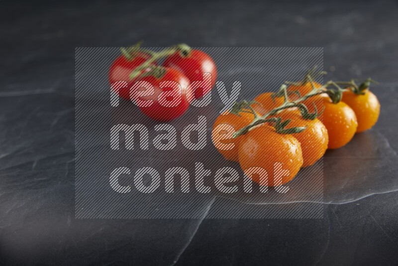 Mixed cherry tomato veins on a textured black slate background 45 degree