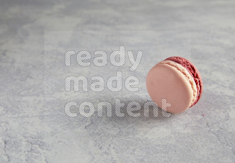 45º Shot of Pink Litchi Raspberry macaron on white  marble background