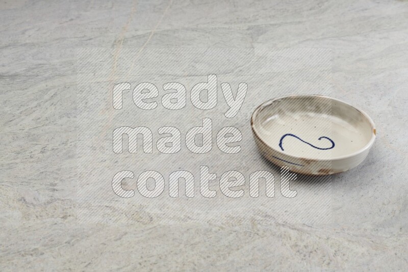 A multicolored pottery bowl on grey marble background